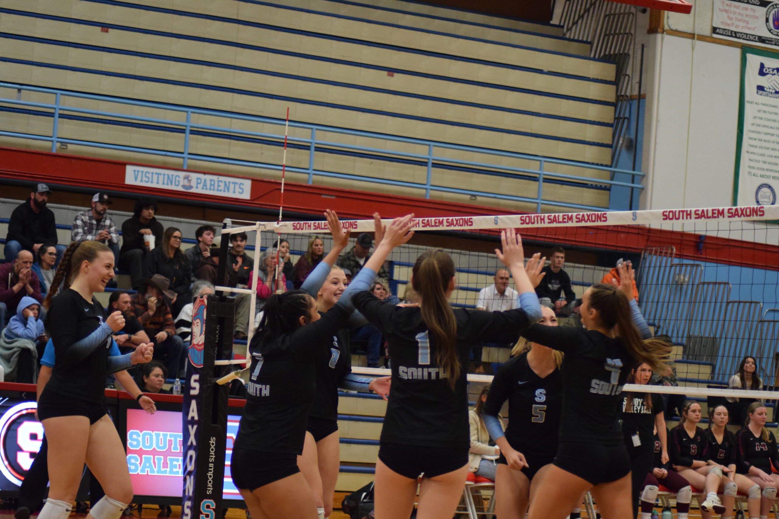 Volleyball players from South Salem High School congratulate one another during their playoff game against Sandy High School.