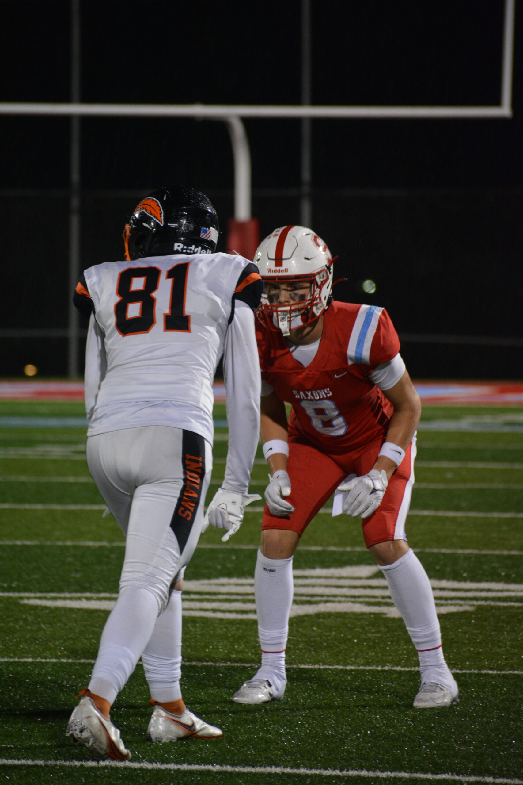 Saxon football player takes a stance in front of a Roseburg football player.