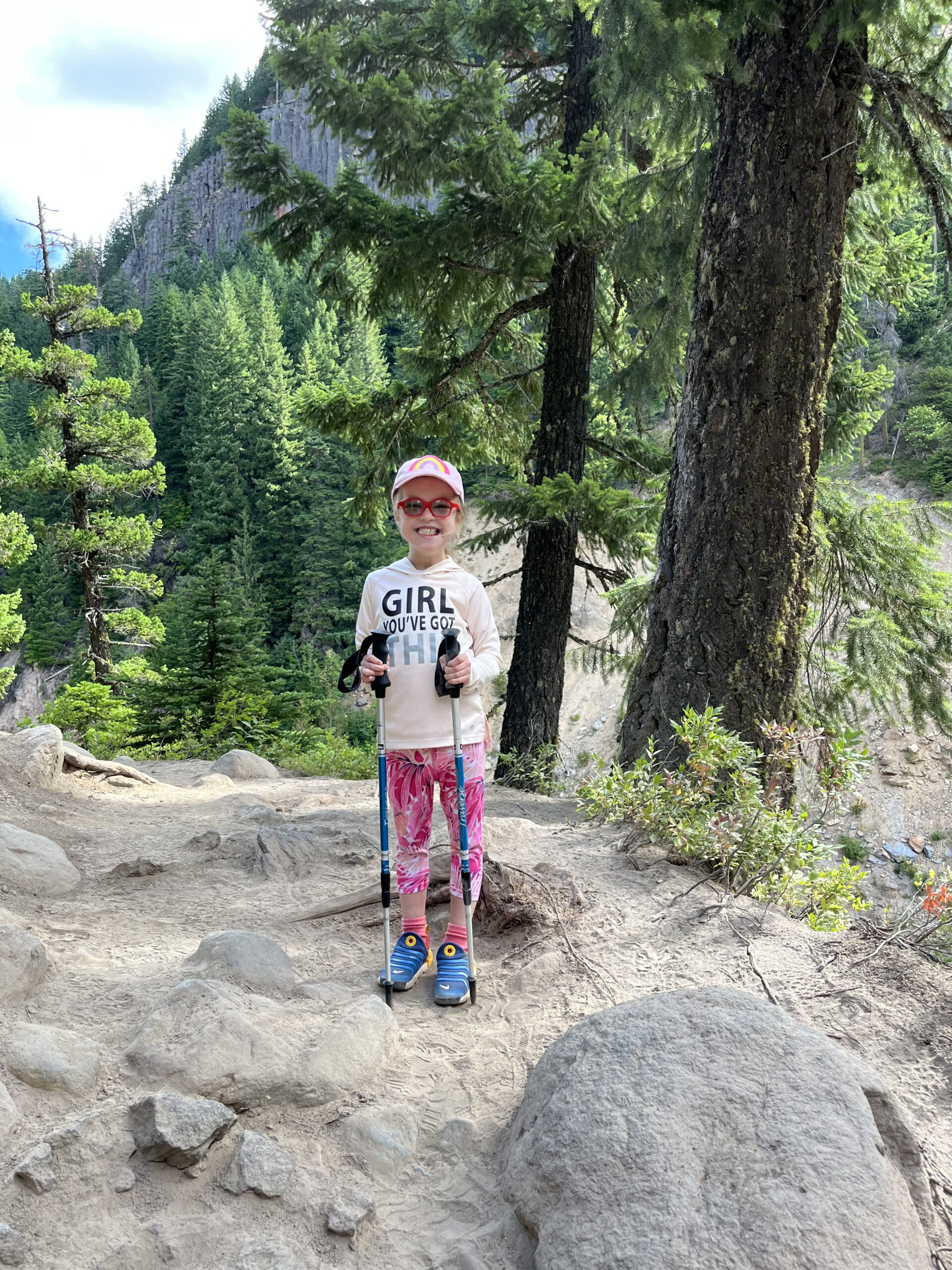 Sammy Hall stands on a mountain while hiking.
