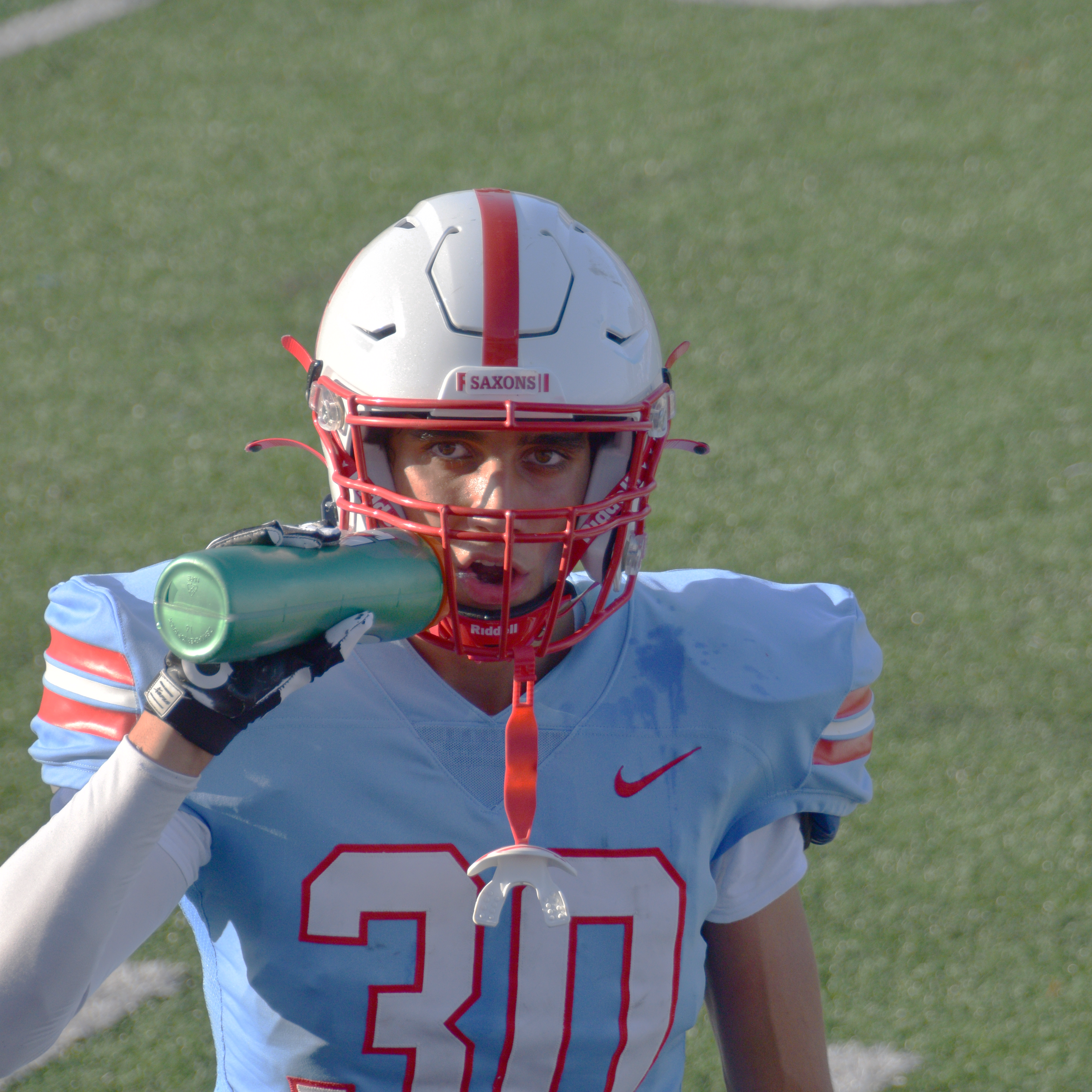 Jose Roquette of South Salem High School drinks water during a football game.