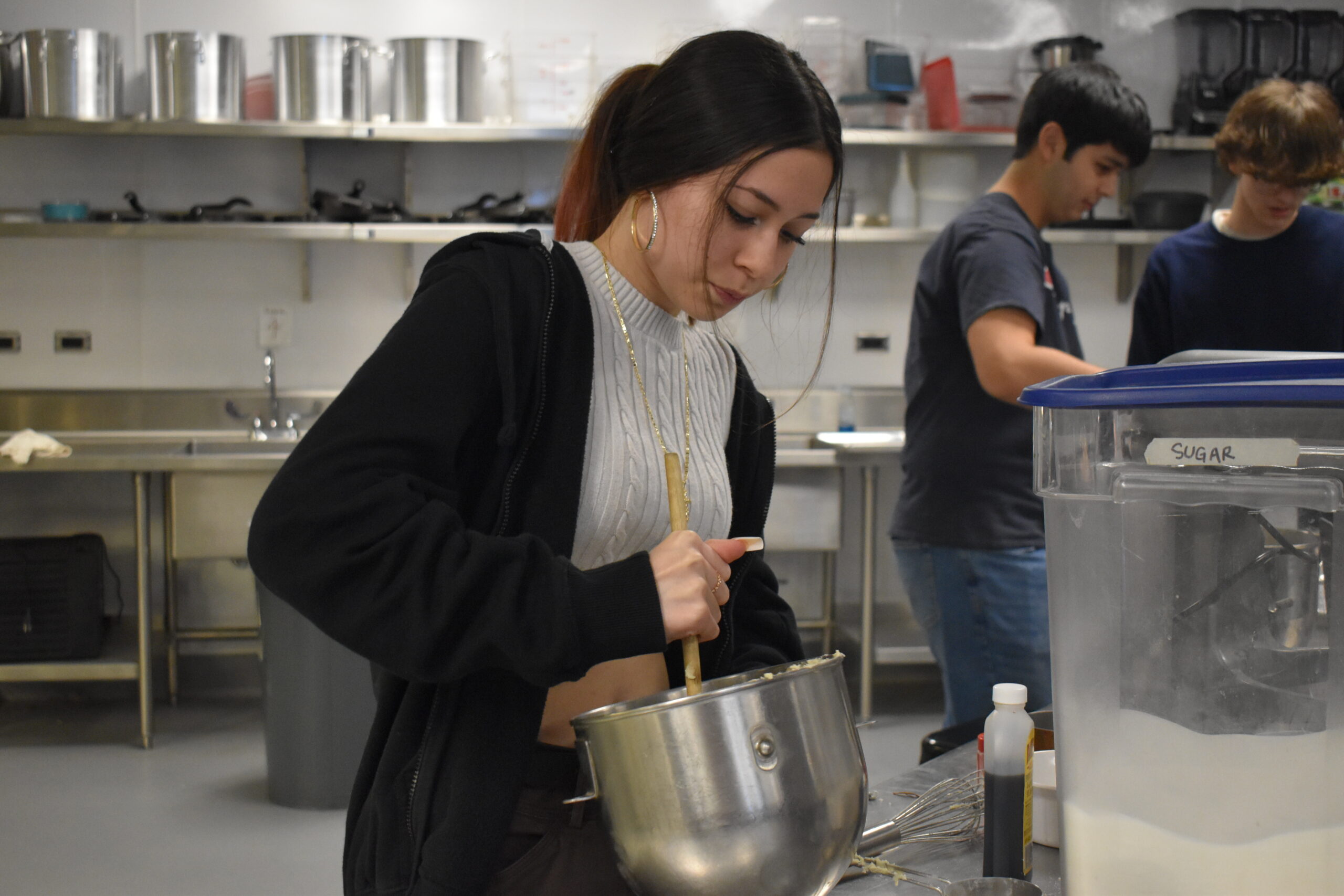 Student mixes up food in Chef Hofer's culinary class.