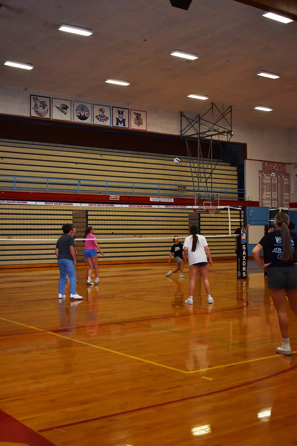 Various students join together in the gym to play a game of volleyball for their Flex activity.