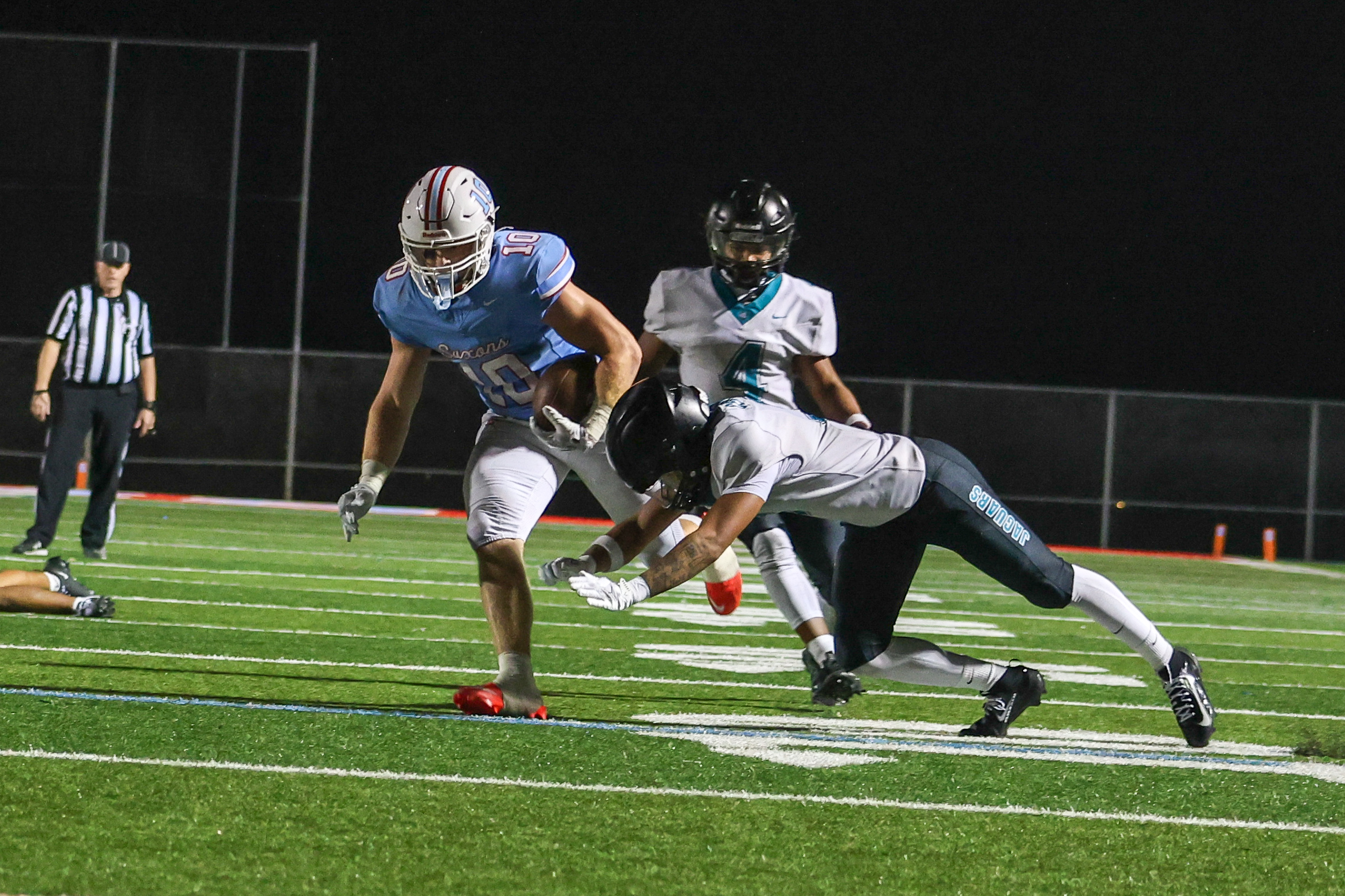 Ben Greer '27 is tackled by two Century players